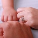Couple with new baby's hands in a circle