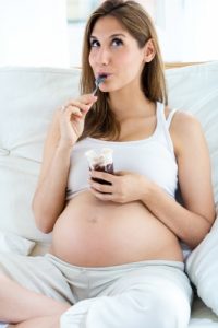 pregnant woman eating yogurt