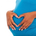 pregnant woman making heart on belly