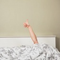 menopausal woman giving thumbs up in bed